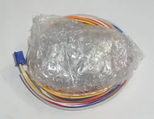 Daikin Elektromagnetventil in plastic schleifen, verpackt in Luftpolsterfolie, umgeben von mehreren farbigen Drähten.